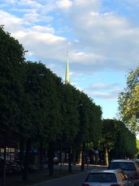 Road by trees against sky