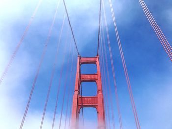 Low angle view of suspension bridge against blue sky