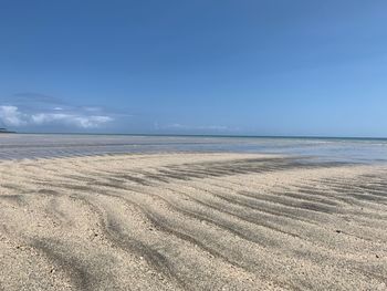 Scenic view of beach against blue sky