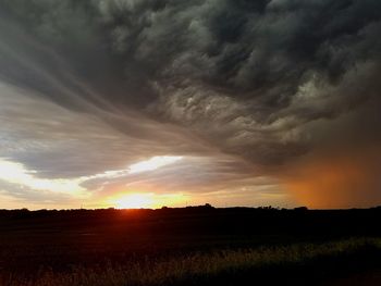 Scenic view of dramatic sky over landscape during sunset