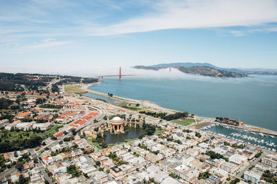 High angle view of townscape by sea against sky