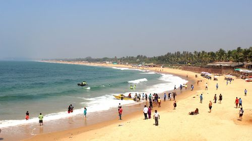 People on beach against clear sky