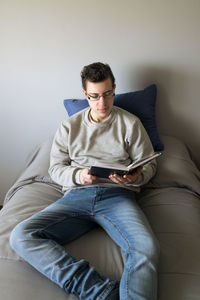 Man lying on bed reading a book