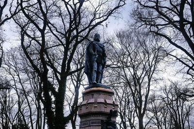Low angle view of statue against bare trees