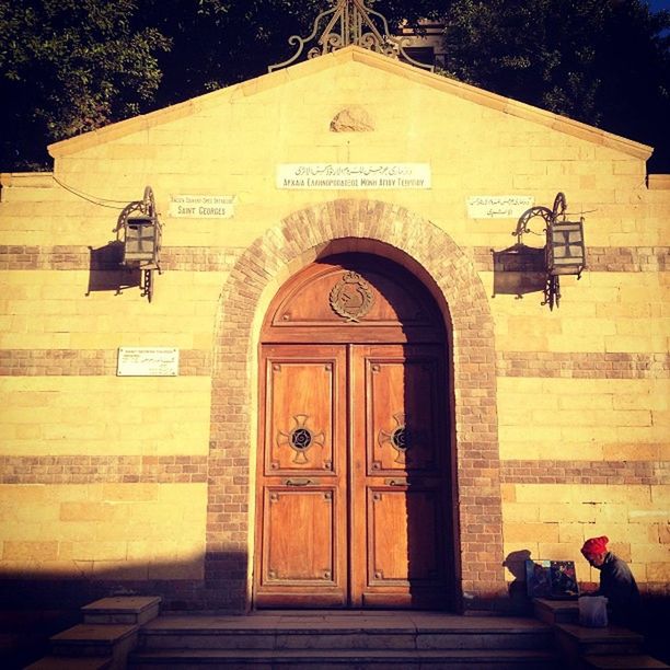 building exterior, architecture, built structure, text, entrance, communication, door, western script, outdoors, facade, closed, non-western script, wall - building feature, men, transportation, street, gate, information sign, day