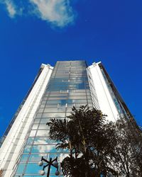 Low angle view of modern building against blue sky