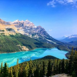 Scenic view of lake and mountains against blue sky