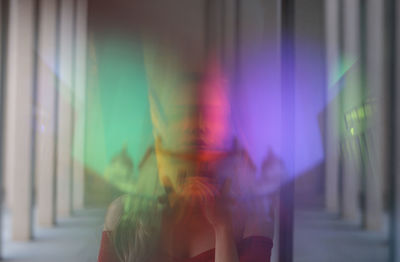Defocused image of woman on multi colored glass window
