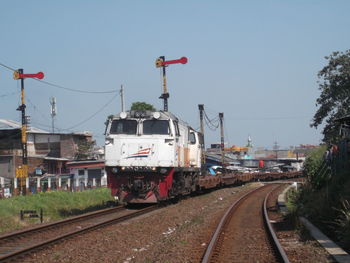 Train on railroad tracks against clear sky