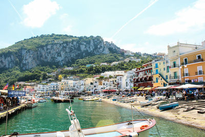 Boats moored on seaside by town