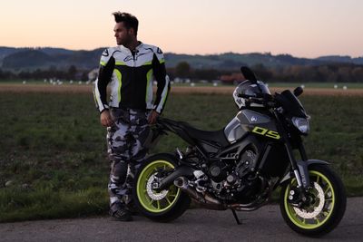 Man riding motorcycle on road against sky