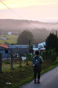 Rear view of man cycling on landscape against sky