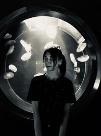 Portrait of smiling young woman standing in corridor