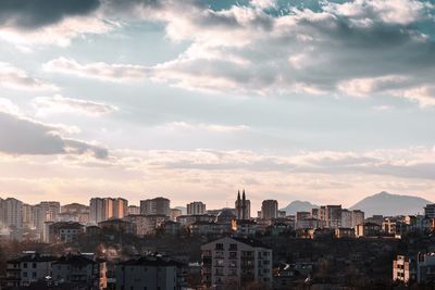 Aerial view of buildings in city against sky