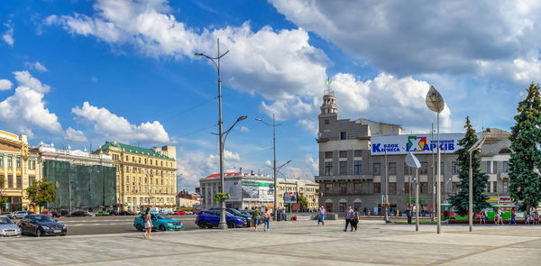 Buildings in city against cloudy sky