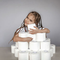 Close-up of smiling girl with toilet paper on table