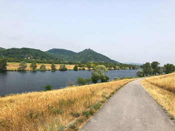 Road by lake against sky