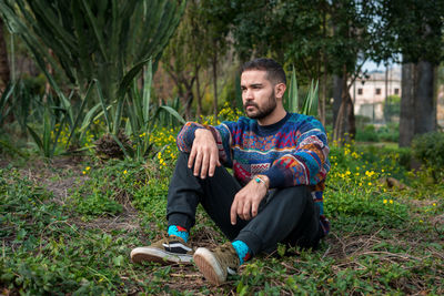 Caucasian model sitting on the ground in a public park