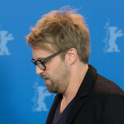 Close-up of man wearing eyeglasses against blue sky