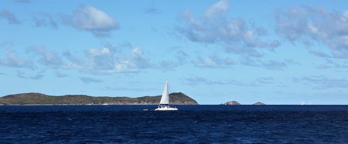 Sailboat sailing on sea against sky