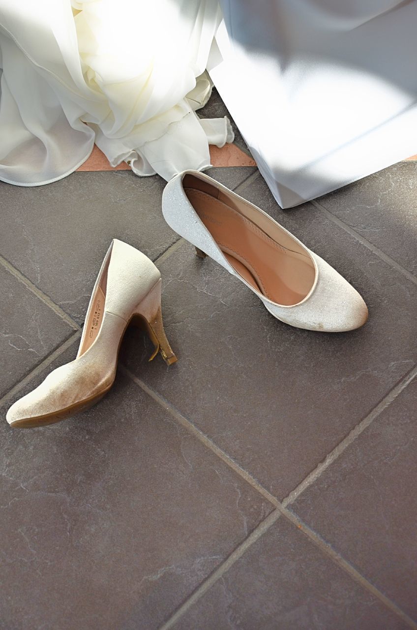 HIGH ANGLE VIEW OF WHITE SHOES ON TILED FLOOR