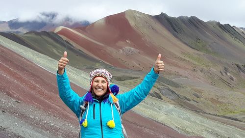 Portrait of smiling woman standing on mountain