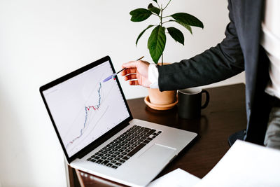 Midsection of man using laptop on table