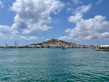 Scenic view of sea by buildings against sky