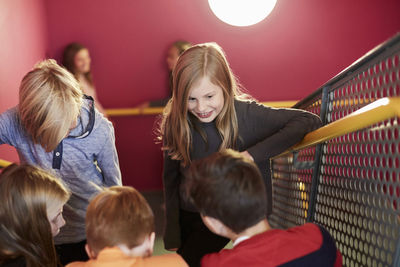 Smiling girl with friends on staircase of middle school