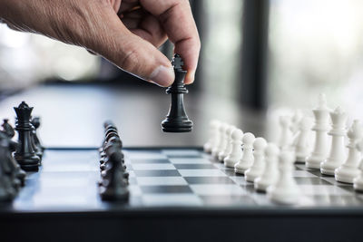 Cropped hand of man playing with chess