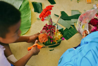 High angle view of boy preparing religious offering