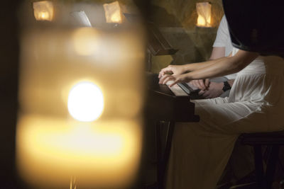 Close-up of hands holding illuminated lamp at night