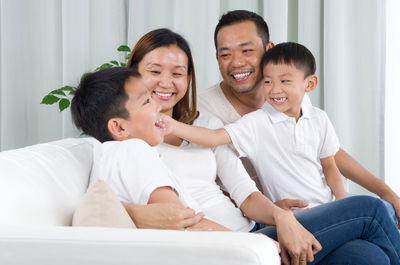 Happy family sitting on sofa at home
