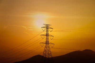 Silhouette electricity pylon against sky during sunset