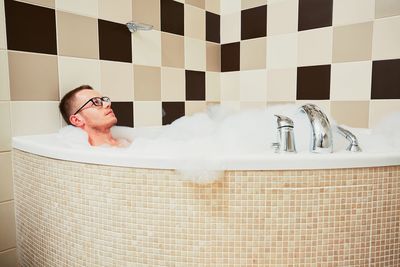 Man lying in bathroom