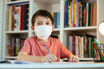 Portrait of boy sitting on book
