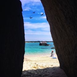 Rear view of woman sitting at beach