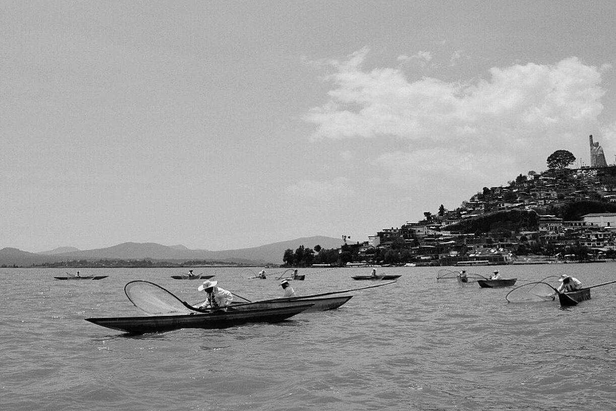 PEOPLE IN BOAT ON SEA AGAINST SKY