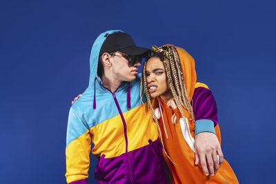 Young couple standing against blue sky