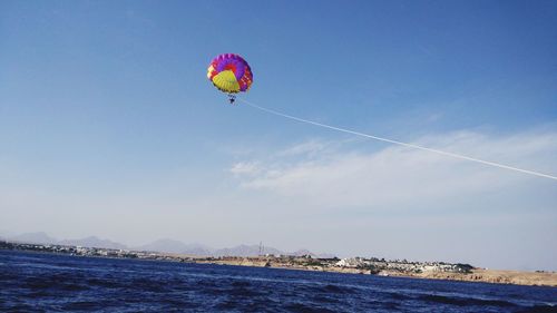 Low angle view of kite flying over sea against sky