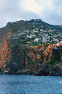 Scenic view of sea by rock formation against sky