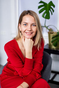 Portrait of young woman sitting on sofa at home