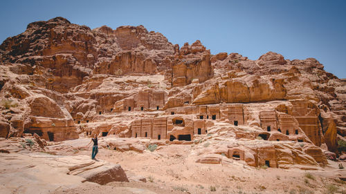 Full length of woman standing on rock formation against ancient civilization