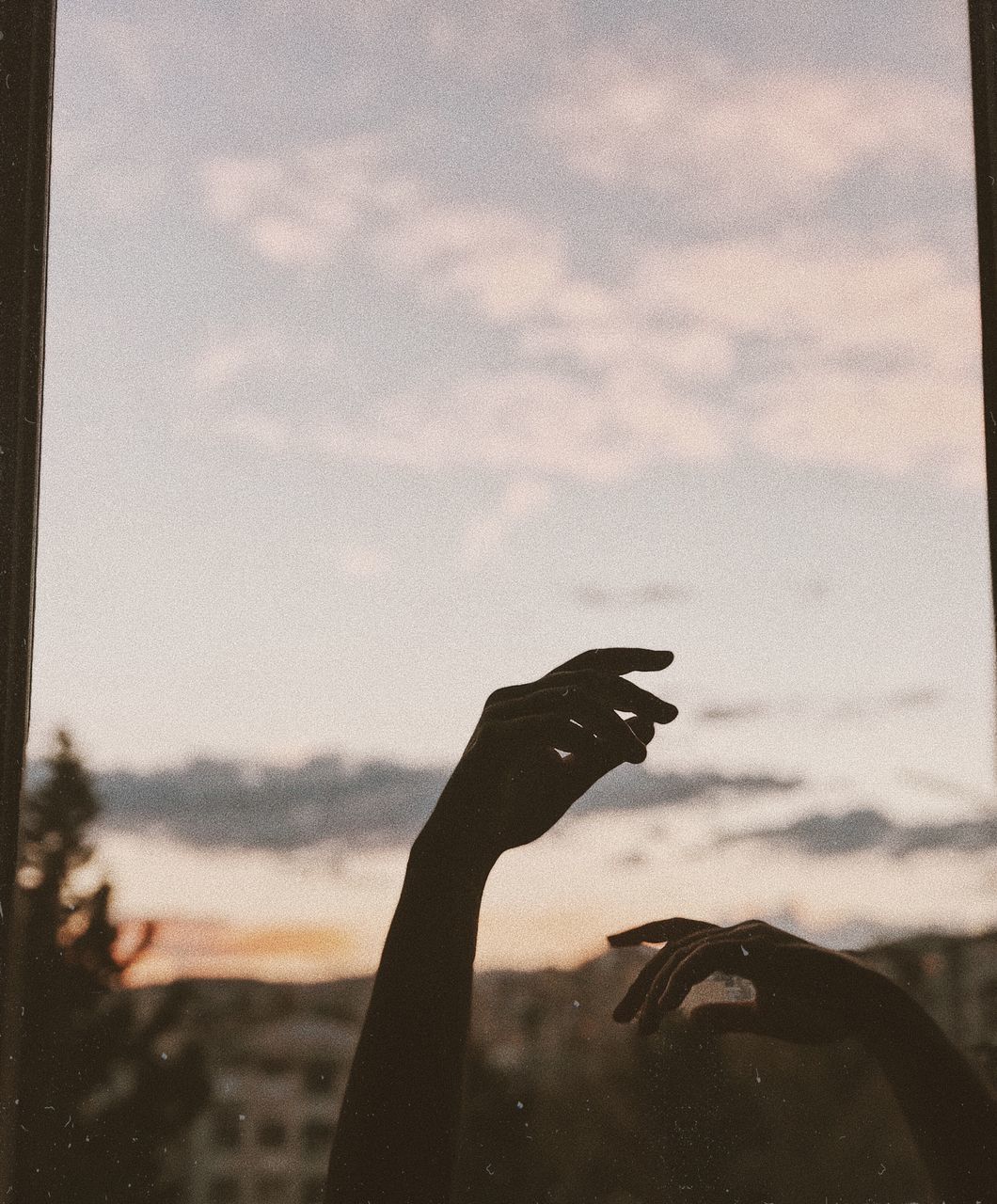 CLOSE-UP OF WOMAN HAND AGAINST SKY DURING SUNSET