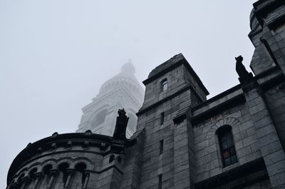 Low angle view of statue against building against clear sky