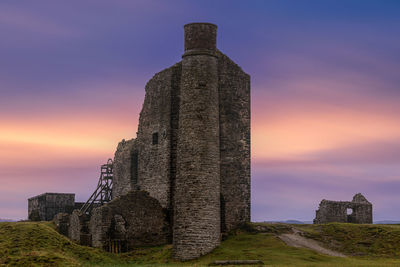 Low angle view of old building against sky during sunset