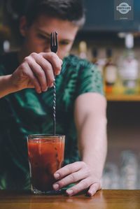 Midsection of man drinking glass on table