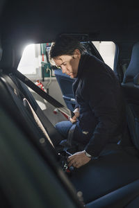 Mechanic repairing car seat belt in auto repair shop