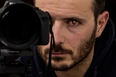 Close-up portrait of man photographing with camera