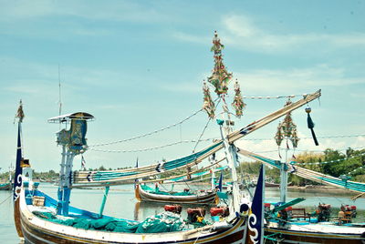 Sailboats moored in sea against sky